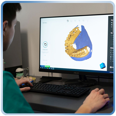 Dentysta sprawdza na komputerze model zębów pacjenta