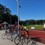 Na zdjęciu rower w tle trasa rowerowa i osoby przechodzące przez nią